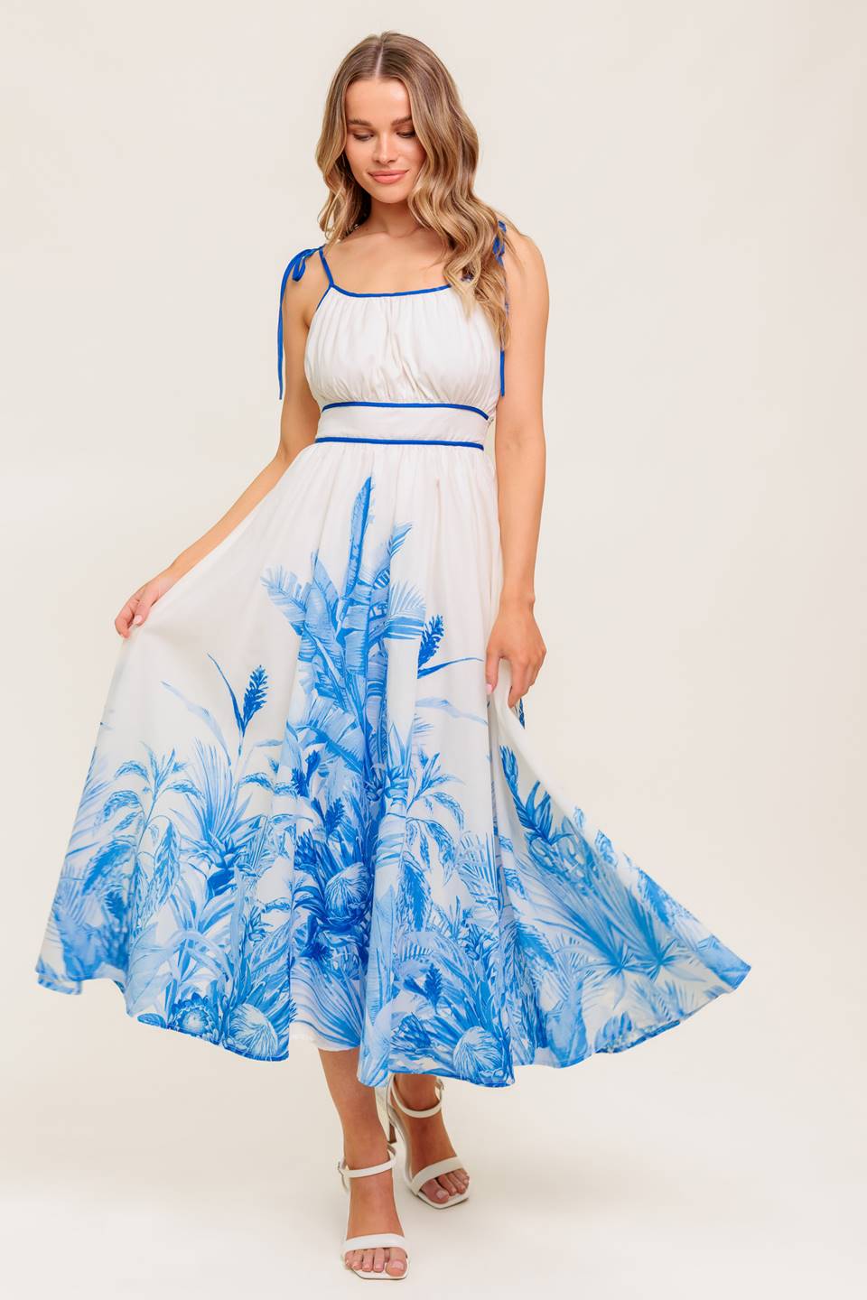 A printed woven midi dress featuring straight neckline, shoulder ties, full skirt and smocked back waistband.