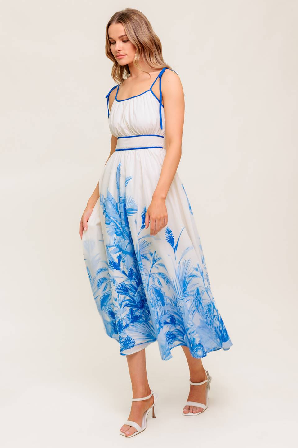 A printed woven midi dress featuring straight neckline, shoulder ties, full skirt and smocked back waistband.