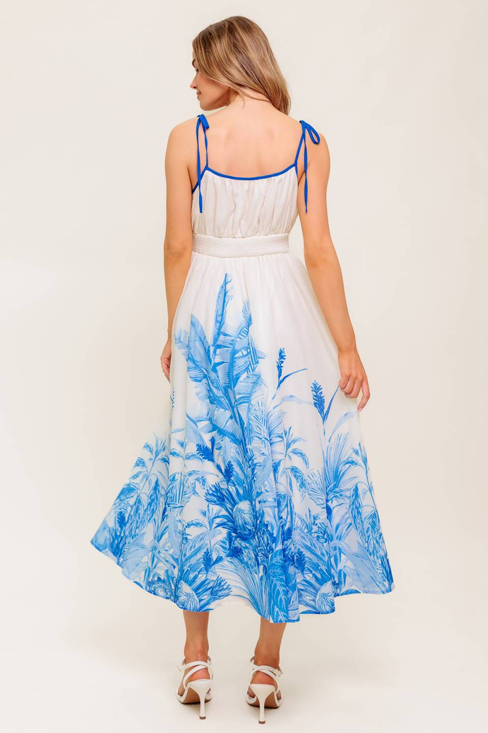 A printed woven midi dress featuring straight neckline, shoulder ties, full skirt and smocked back waistband.
