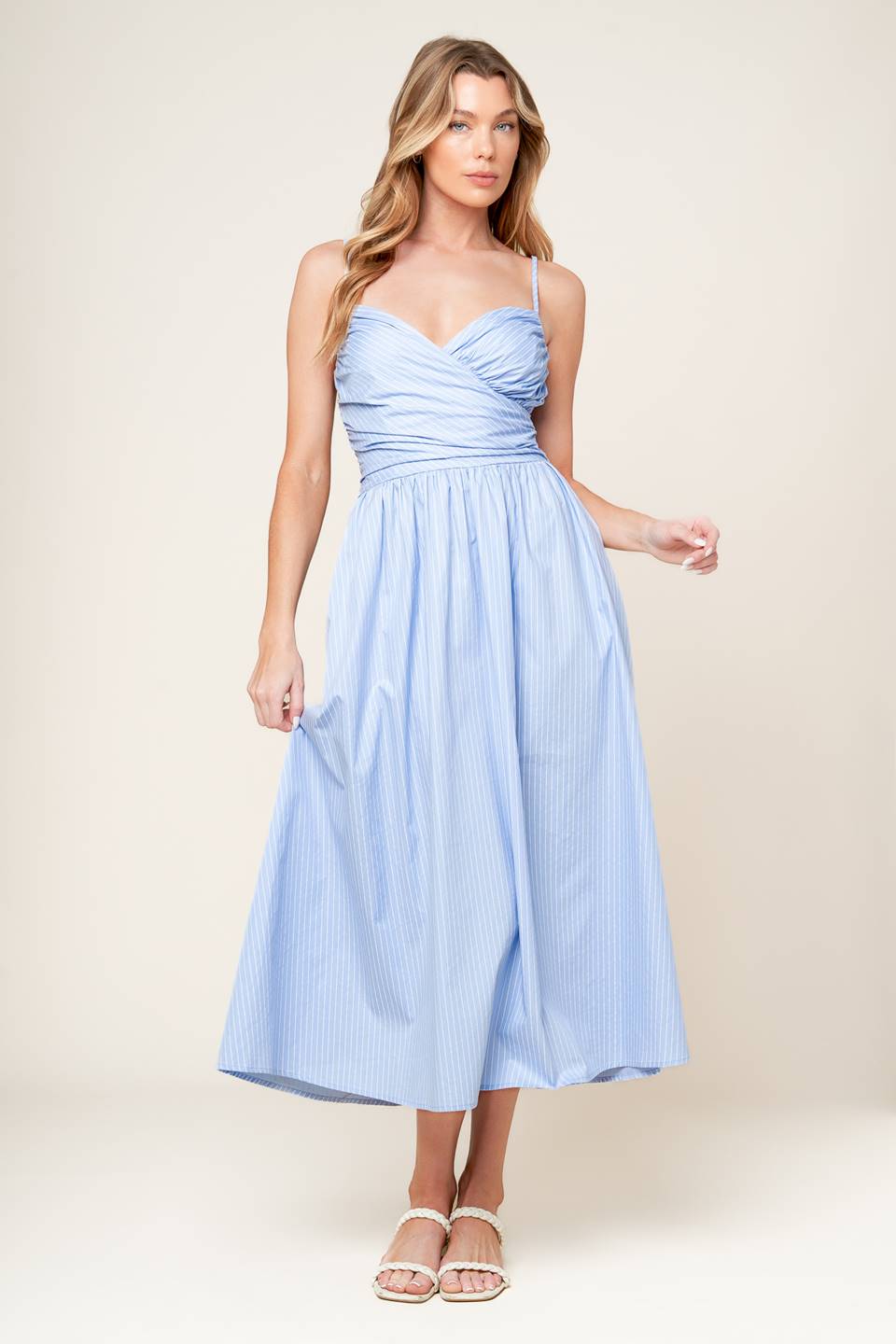 A striped woven midi dress featuring surplice neckline with shirred bodice, full skirt and smocked back bodice.