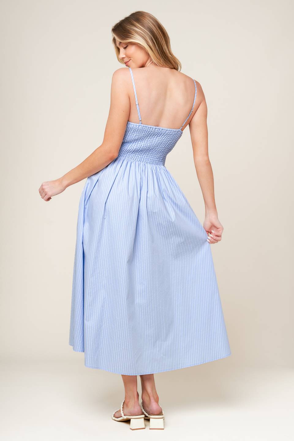 A striped woven midi dress featuring surplice neckline with shirred bodice, full skirt and smocked back bodice.