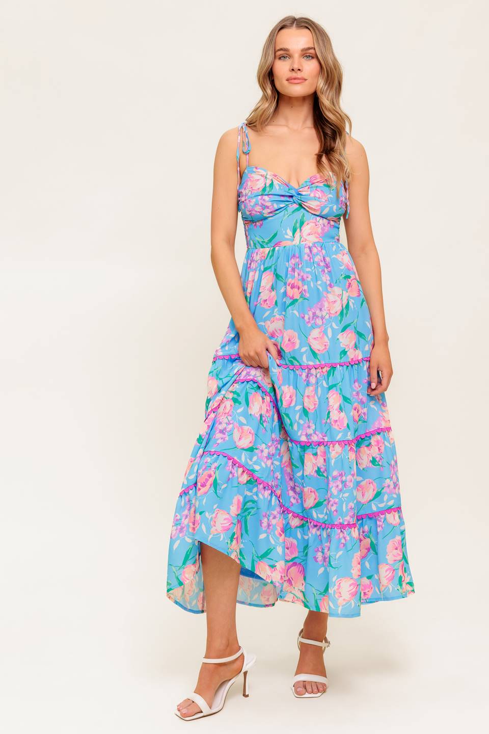 A printed woven midi dress featuring twisted bodice, waist yoke, shoulder ties, tiered skirt with lace edge and smocked back bodice.
