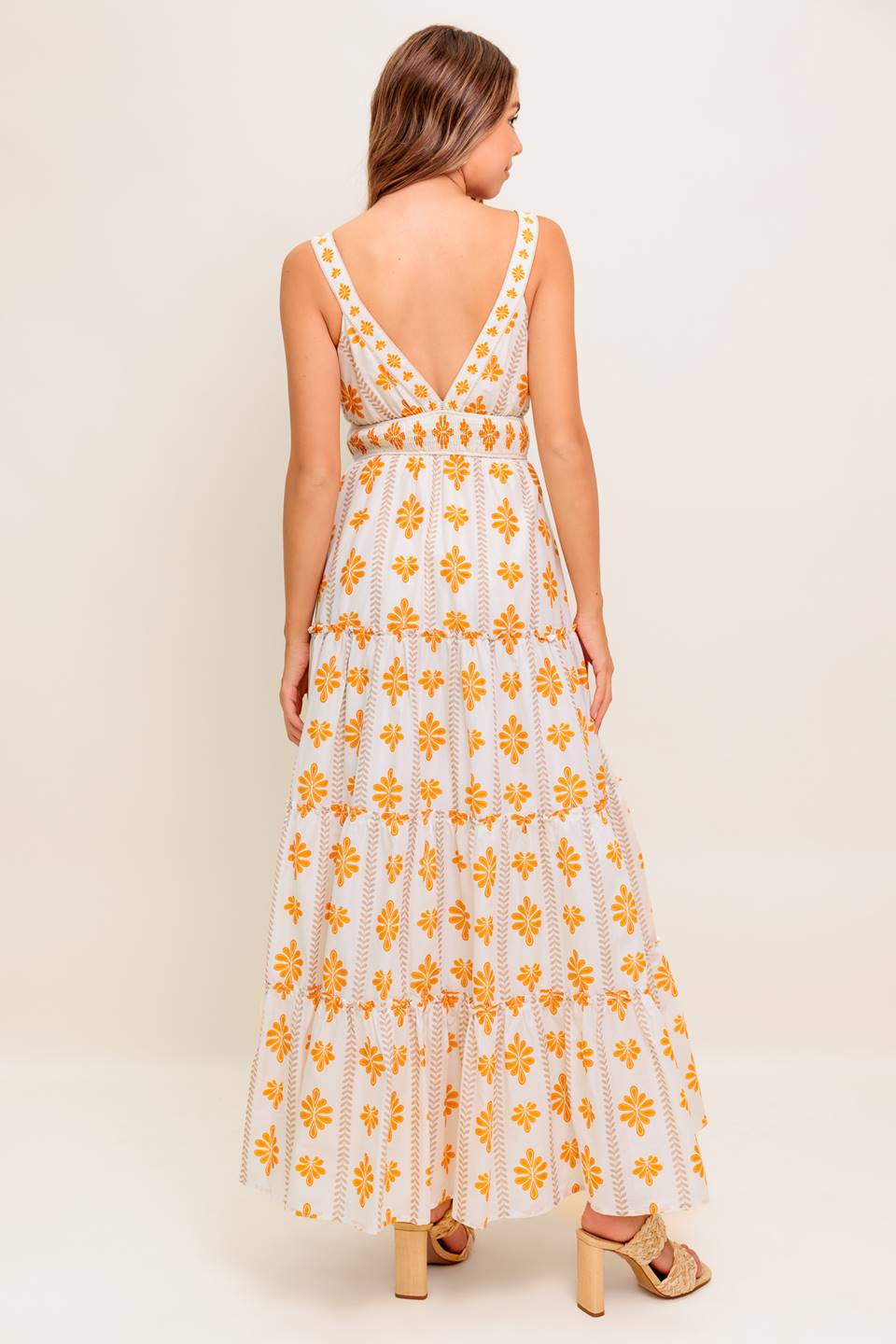 A printed woven maxi dress featuring V neckline, smocked waistband and tiered skirt with ruffled edge.