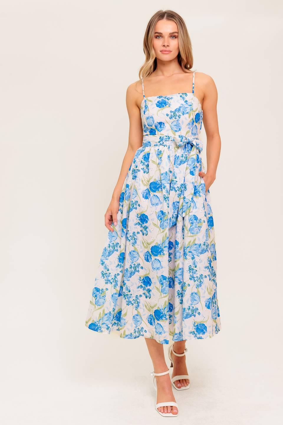 A floral printed woven midi dress featuring straight neckline, straps, self sash tie, full skirt and smocked back bodice.
