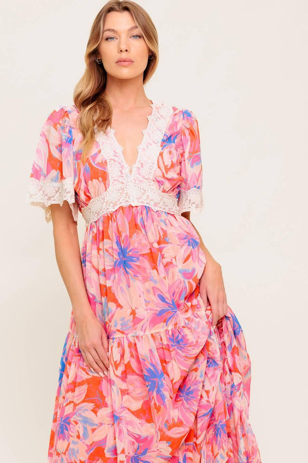 A printed woven maxi dress featuring lace trimmed V neckline, short flutter sleeve with lace hem, lace waistband, tiered skirt and smocked back waistband.