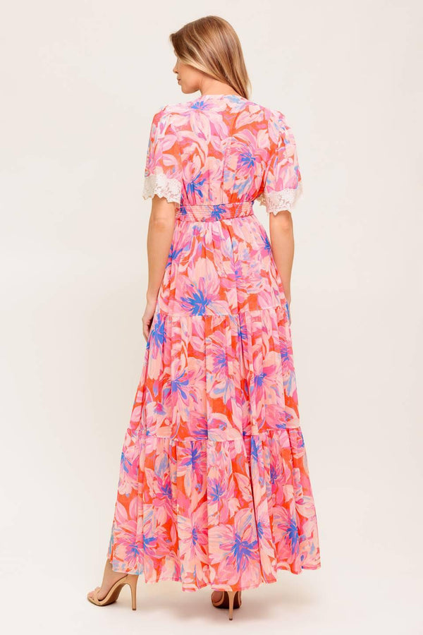 A printed woven maxi dress featuring lace trimmed V neckline, short flutter sleeve with lace hem, lace waistband, tiered skirt and smocked back waistband.