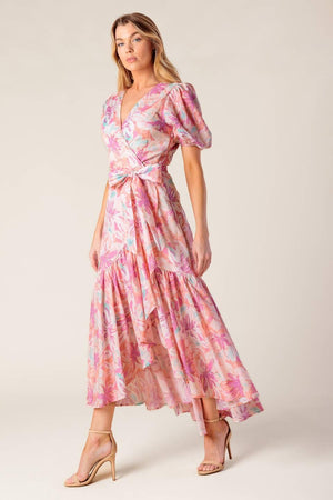A printed woven hi-lo midi dress featuring surplice neckline, short puff sleeve, self sash tie and ruffled hemline