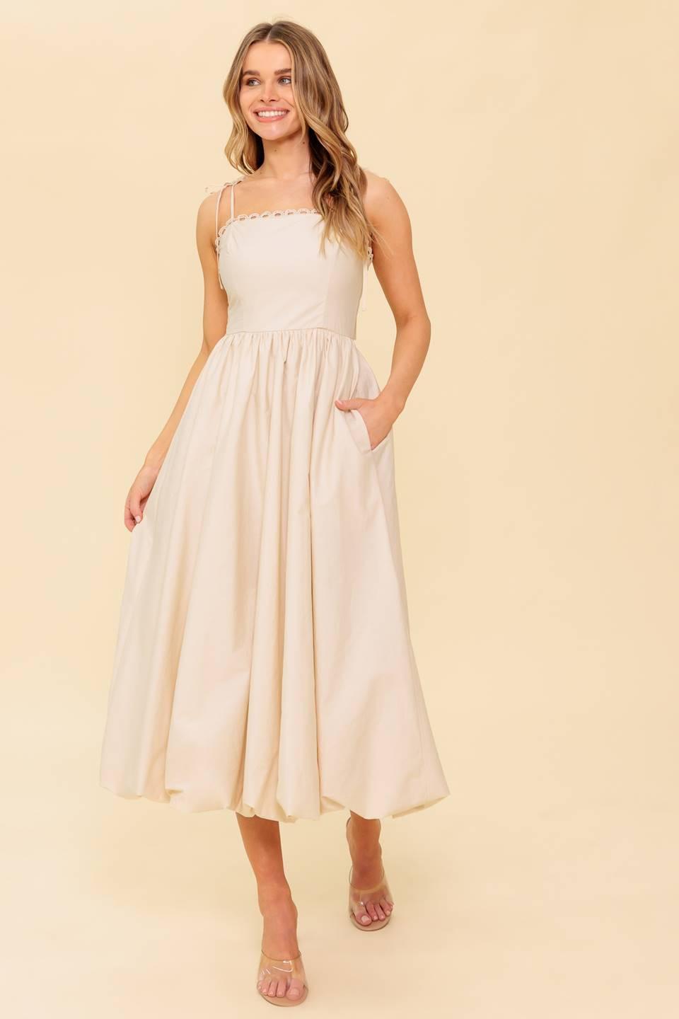 A solid woven midi dress featuring straight neckline with lace edge, shoulder ties, bubble hemline and back zipper closure