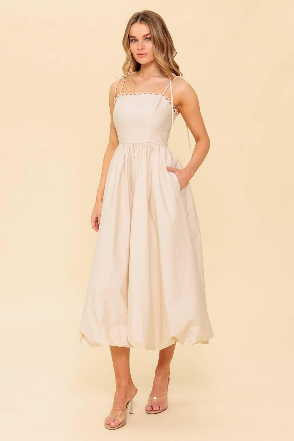 A solid woven midi dress featuring straight neckline with lace edge, shoulder ties, bubble hemline and back zipper closure