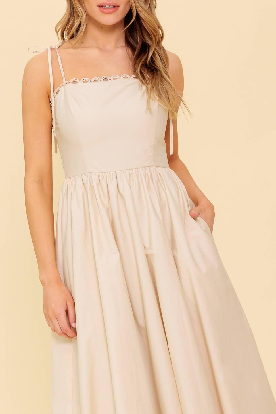 A solid woven midi dress featuring straight neckline with lace edge, shoulder ties, bubble hemline and back zipper closure