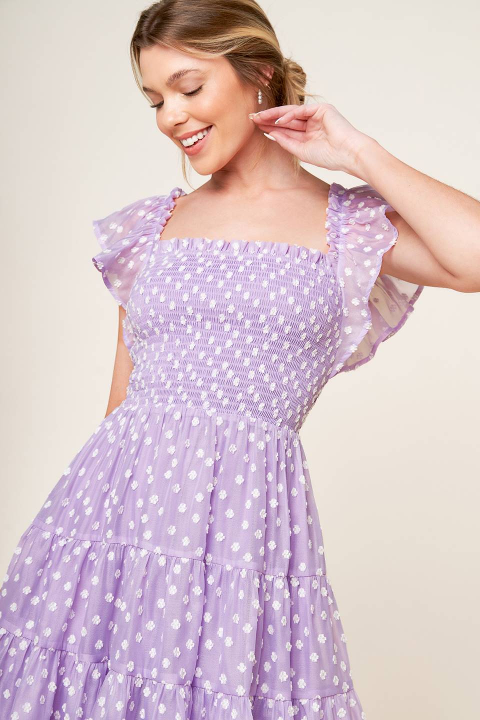 A textured lavender woven mini dress featuring square neckline, ruffled sleeve, smocked bodice and tiered skirt.