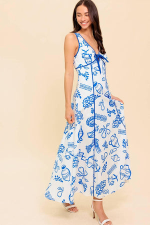 A printed woven ankle dress featuring V neckline with front bow tie, sleeveless, full skirt and plunging V back with zipper closure