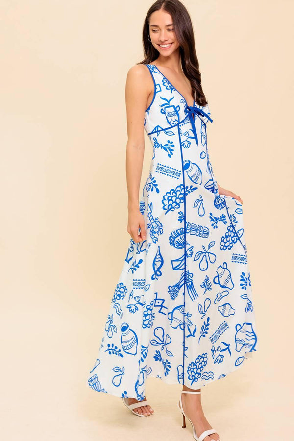 A printed woven ankle dress featuring V neckline with front bow tie, sleeveless, full skirt and plunging V back with zipper closure
