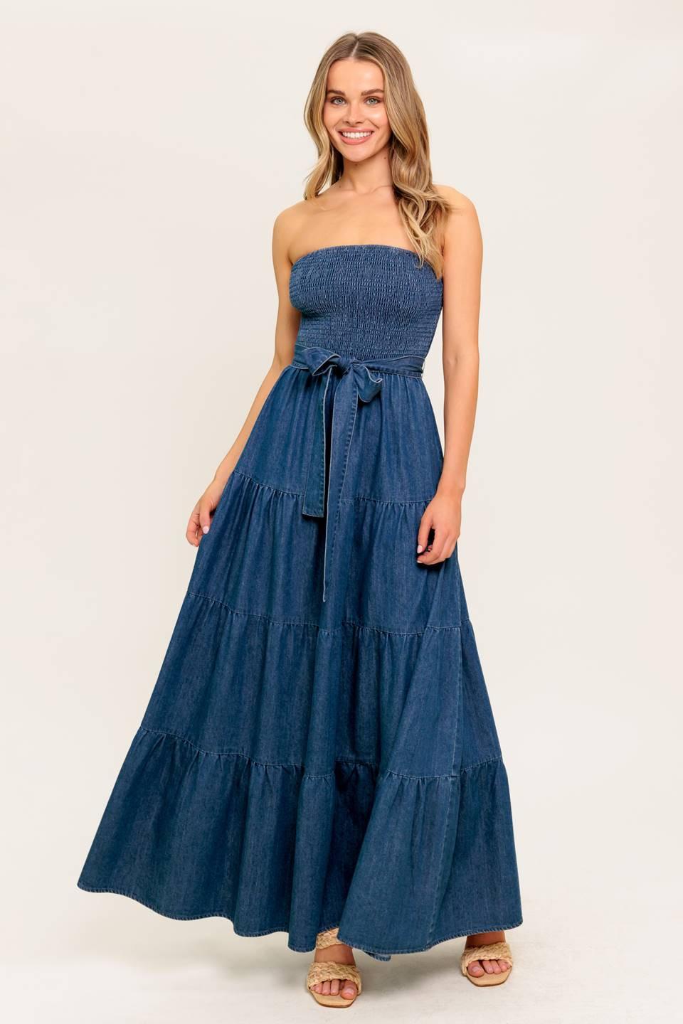 A strapless, washed denim midi dress featuring a smocked bodice, tiered skirt, and self-sash tie.
