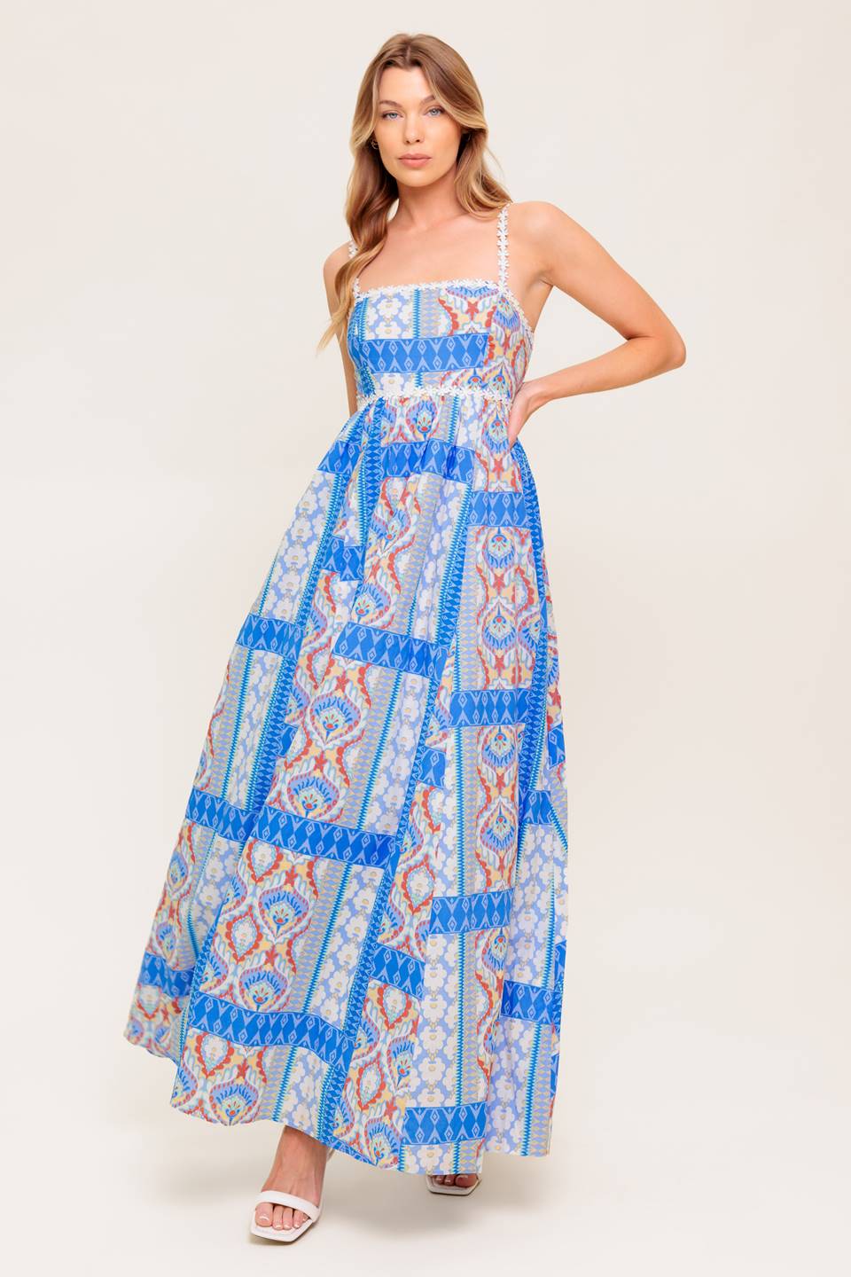 A printed woven maxi dress featuring straight neckline with lace trim, lace shoulder strap, full skirt and smocked back bodice.