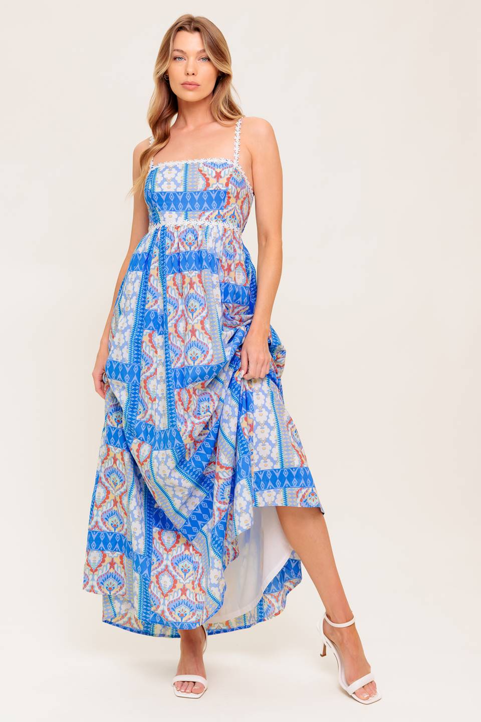 A printed woven maxi dress featuring straight neckline with lace trim, lace shoulder strap, full skirt and smocked back bodice.