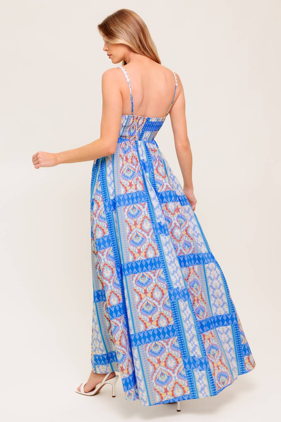 A printed woven maxi dress featuring straight neckline with lace trim, lace shoulder strap, full skirt and smocked back bodice.