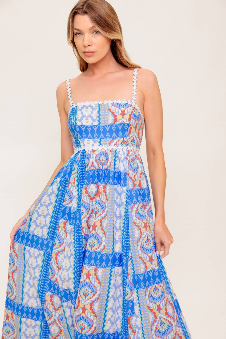 A printed woven maxi dress featuring straight neckline with lace trim, lace shoulder strap, full skirt and smocked back bodice.