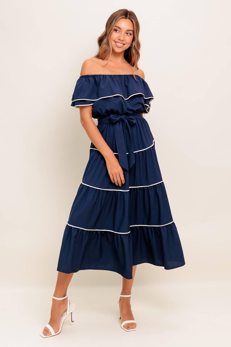 A solid navy woven midi dress featuring off shoulder neckline with flounce, elasticized waist, self sash tie and tiered skirt