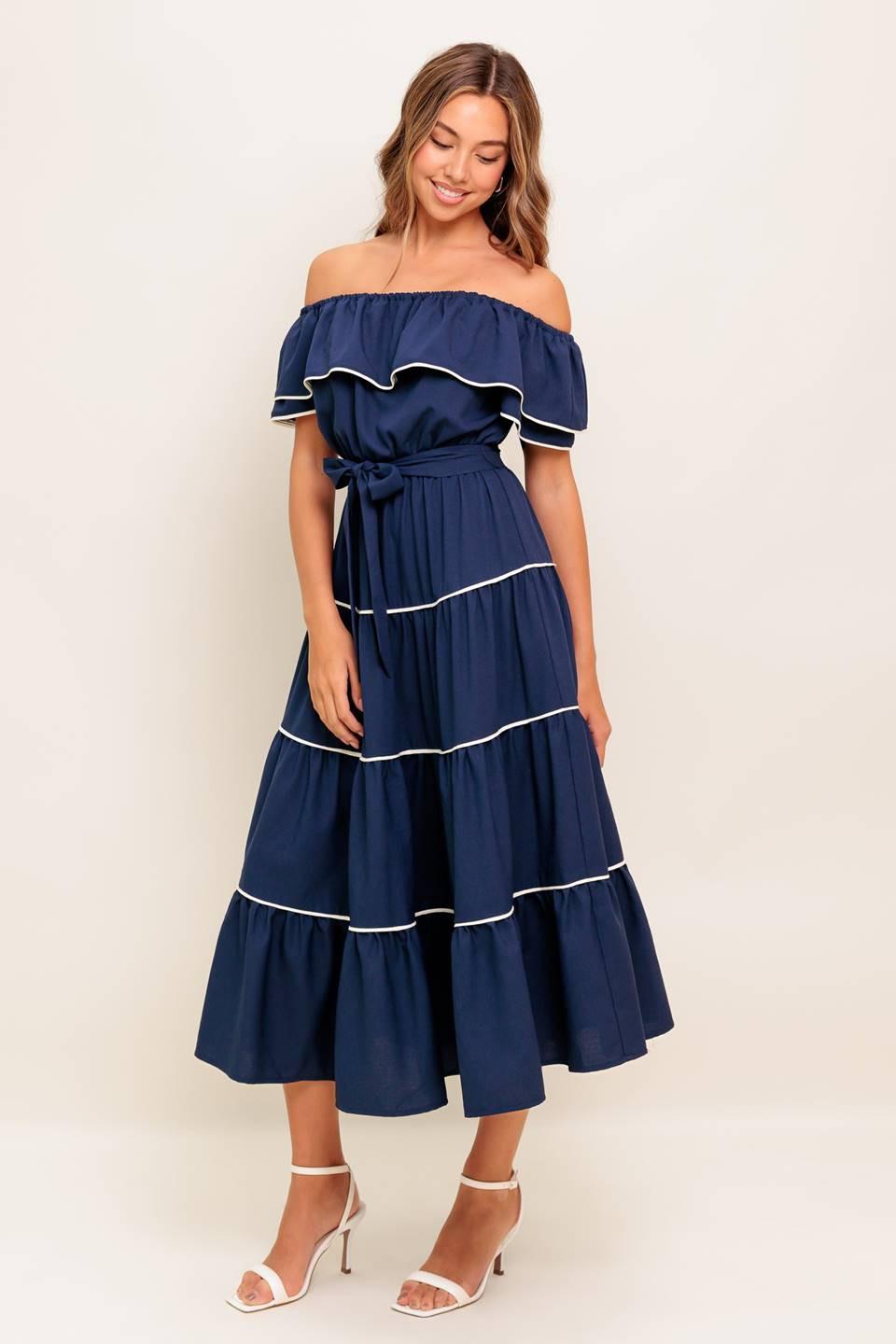 A solid navy woven midi dress featuring off shoulder neckline with flounce, elasticized waist, self sash tie and tiered skirt