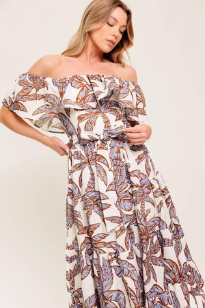 A printed woven midi dress featuring off shoulder neckline, flounce, elasticized waist with self sash tie and tiered skirt.