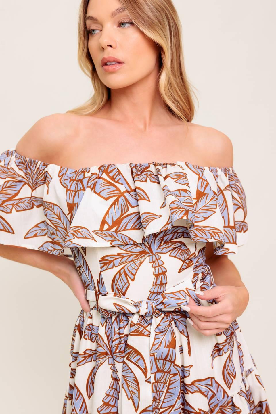 A printed woven midi dress featuring off shoulder neckline, flounce, elasticized waist with self sash tie and tiered skirt.