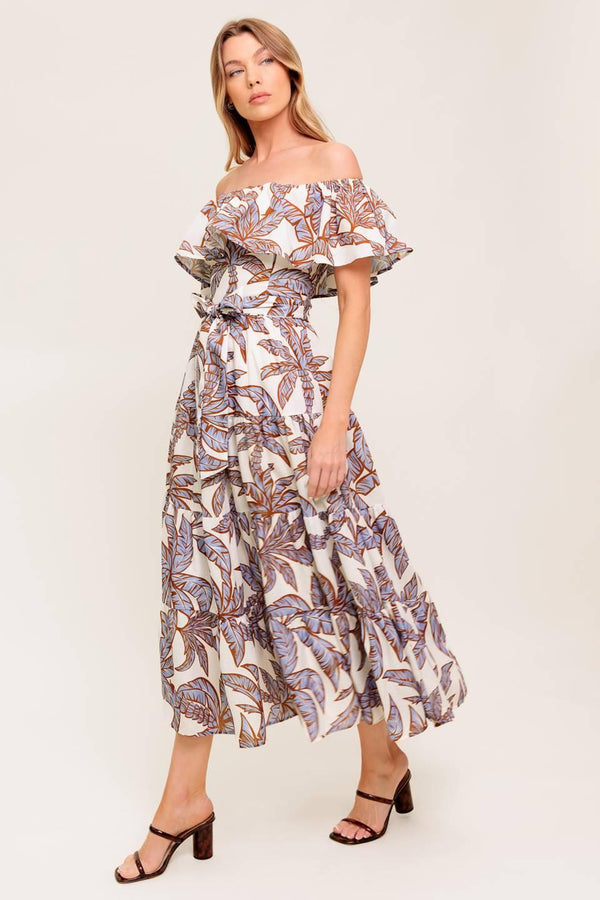 A printed woven midi dress featuring off shoulder neckline, flounce, elasticized waist with self sash tie and tiered skirt.