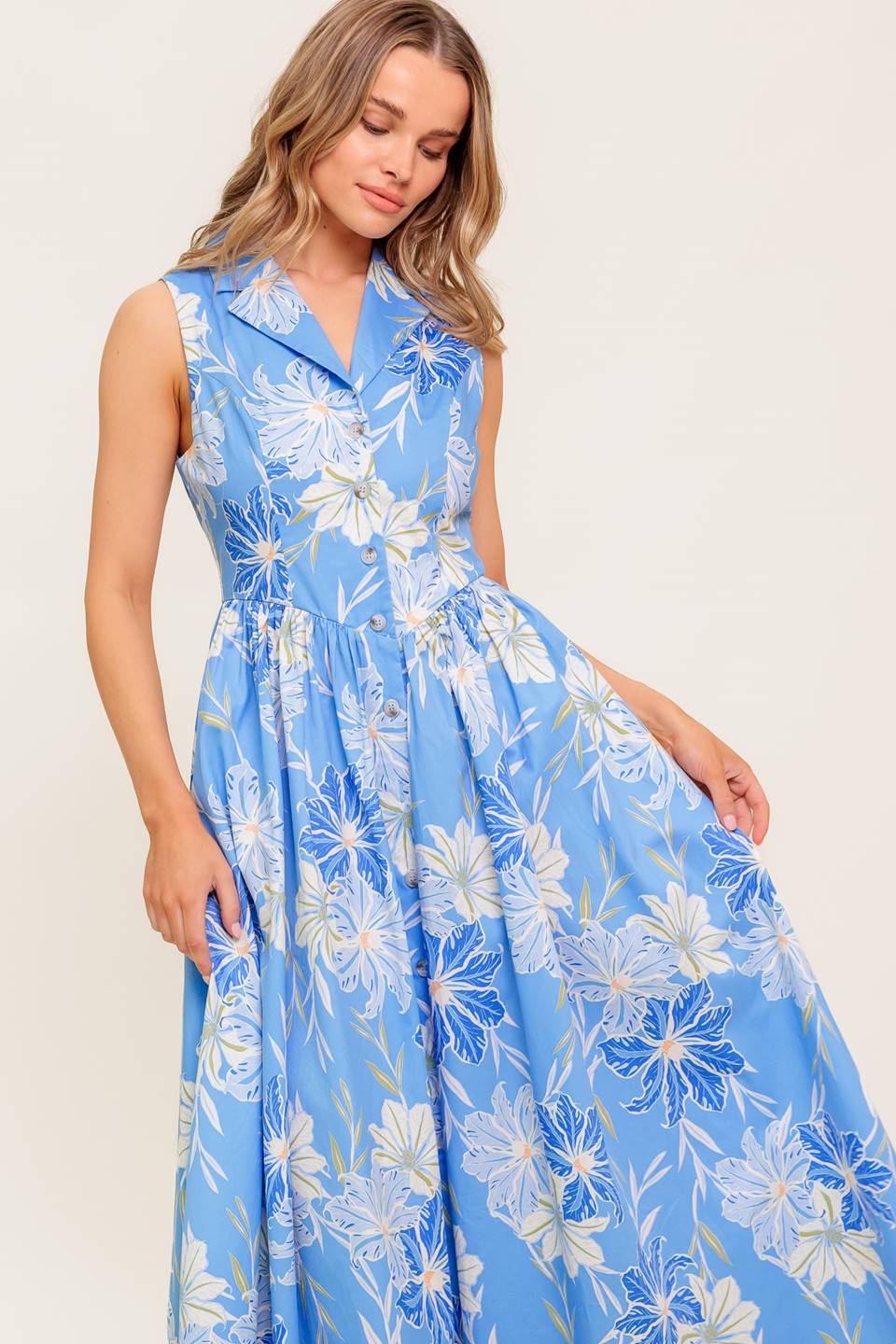 A printed woven midi dress featuring collar, sleeveless, basque waistline and button down closure.