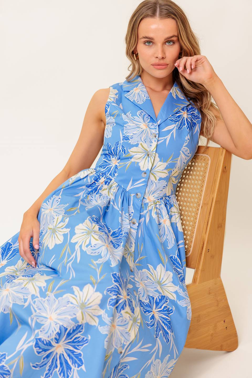 A printed woven midi dress featuring collar, sleeveless, basque waistline and button down closure.