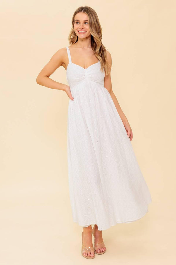 A solid white eyelet midi dress featuring sweetheart neckline, straps, full skirt and smocked back bodice