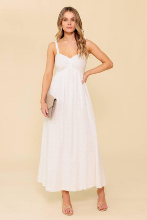 A solid white eyelet midi dress featuring sweetheart neckline, straps, full skirt and smocked back bodice