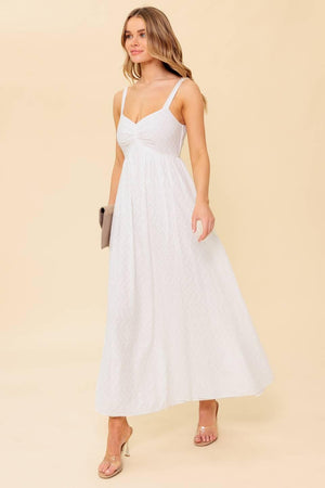 A solid white eyelet midi dress featuring sweetheart neckline, straps, full skirt and smocked back bodice