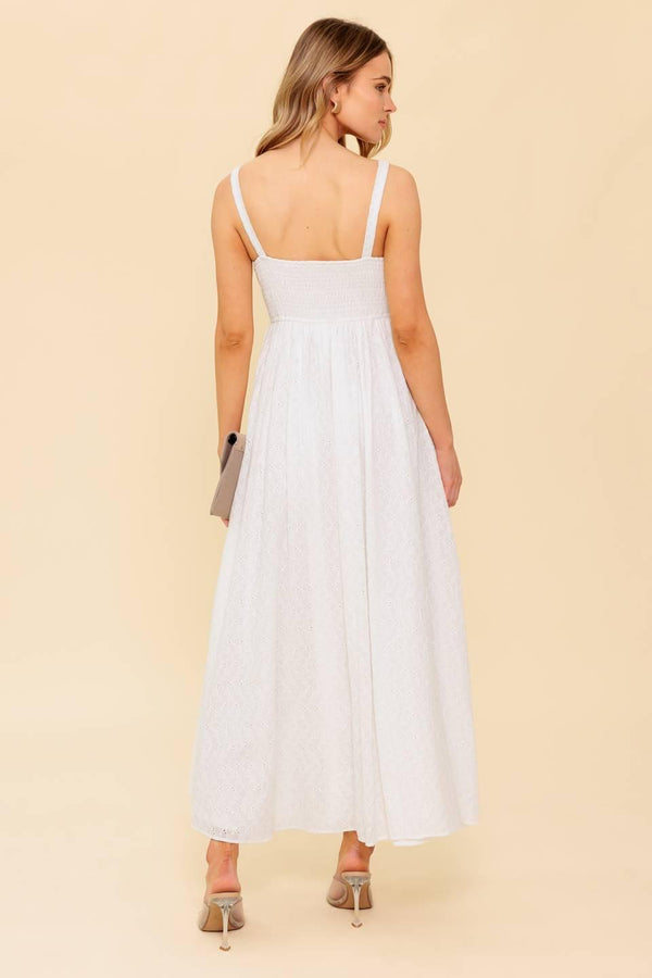 A solid white eyelet midi dress featuring sweetheart neckline, straps, full skirt and smocked back bodice