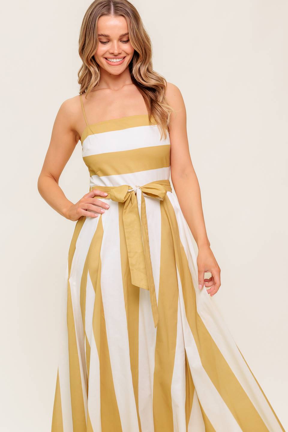 A printed woven midi dress featuring straight neckline, straps, self sash tie, circle skirt and back zipper closure.
