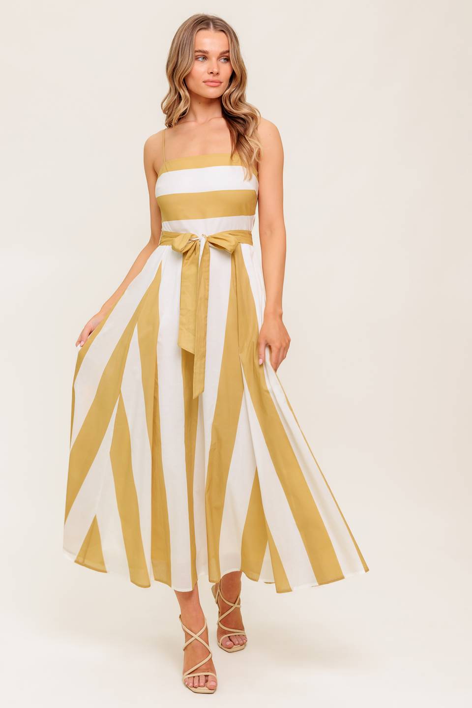 A printed woven midi dress featuring straight neckline, straps, self sash tie, circle skirt and back zipper closure.