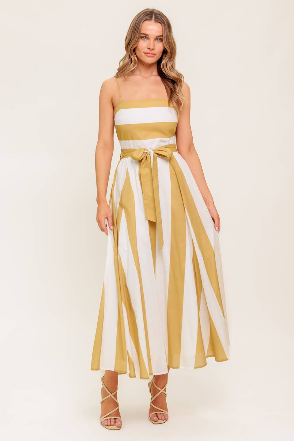 A printed woven midi dress featuring straight neckline, straps, self sash tie, circle skirt and back zipper closure.