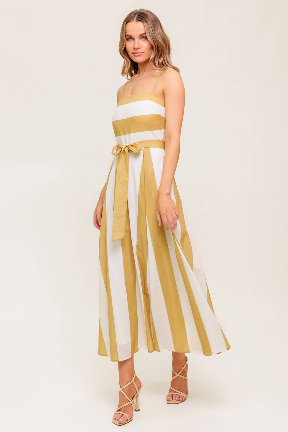 A printed woven midi dress featuring straight neckline, straps, self sash tie, circle skirt and back zipper closure.