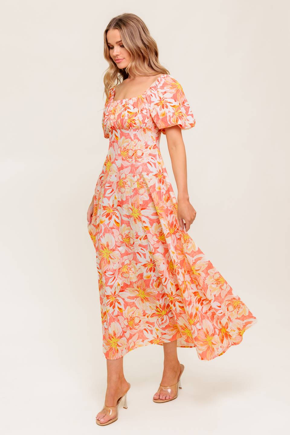 A printed woven midi dress featuring square neckline, short puff sleeve, shirred bodice, circle skirt and back zipper closure
