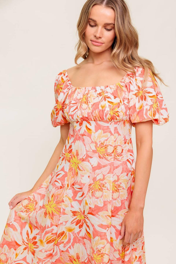 A printed woven midi dress featuring square neckline, short puff sleeve, shirred bodice, circle skirt and back zipper closure