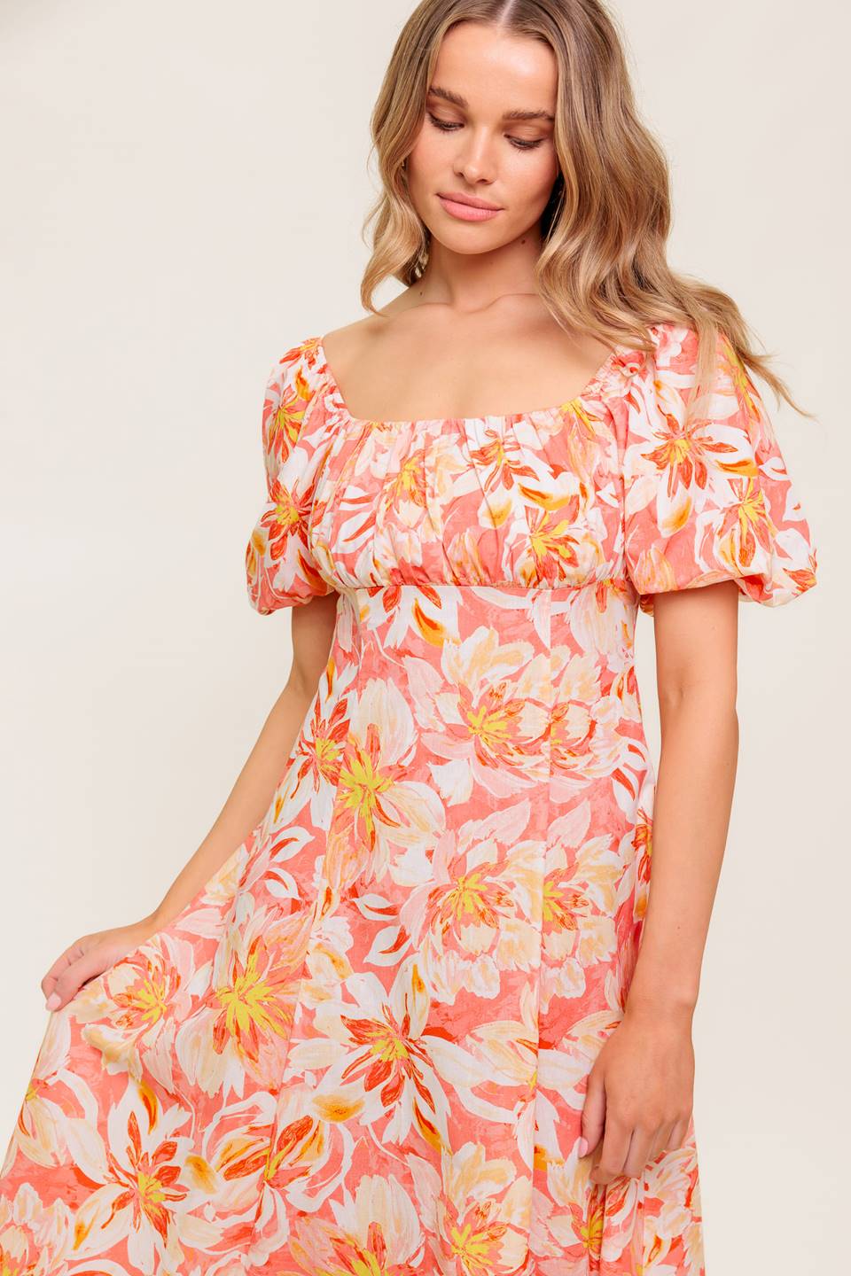 A printed woven midi dress featuring square neckline, short puff sleeve, shirred bodice, circle skirt and back zipper closure