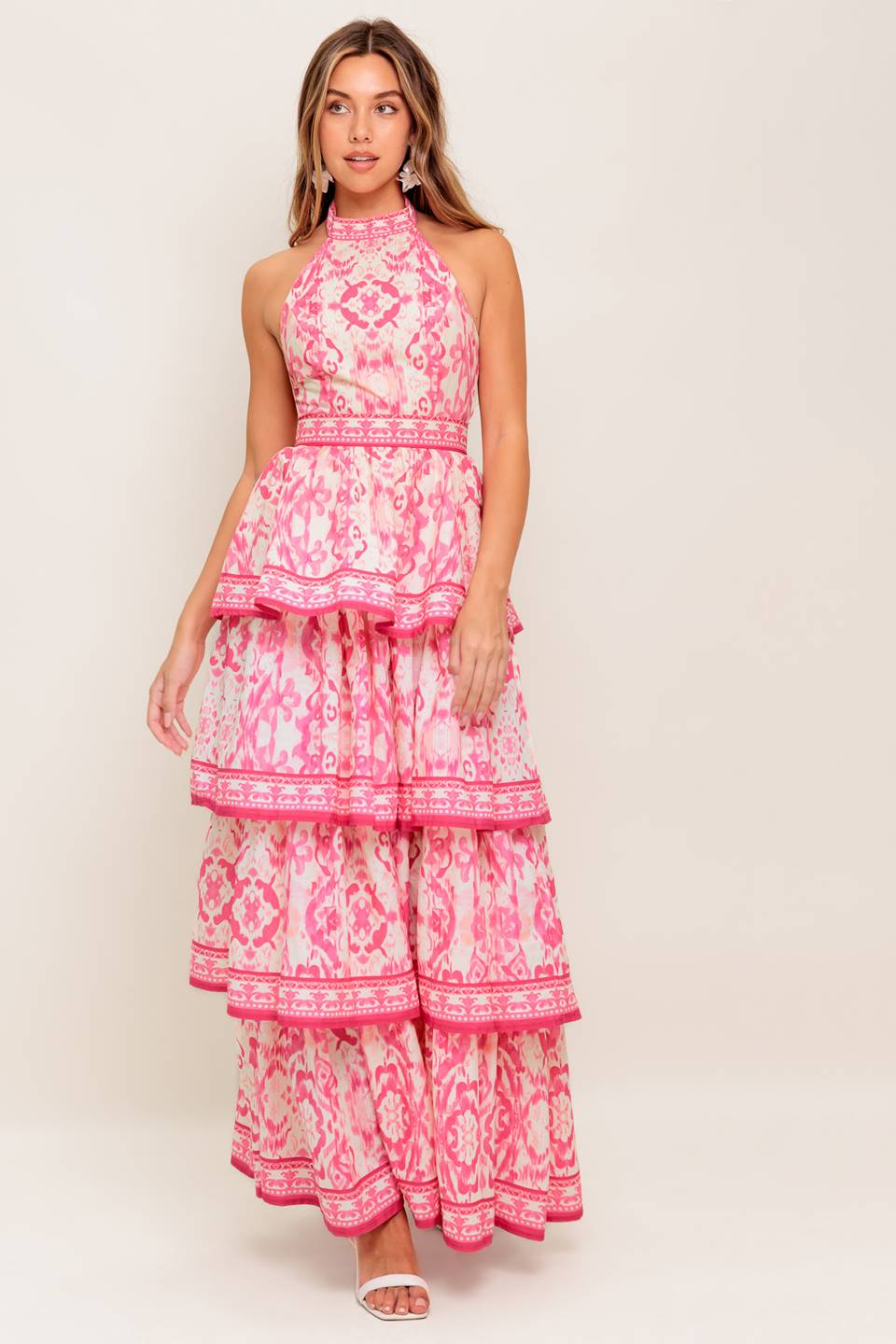 A printed woven maxi dress featuring halter neckline, sleeveless, layered skirt and back zipper closure