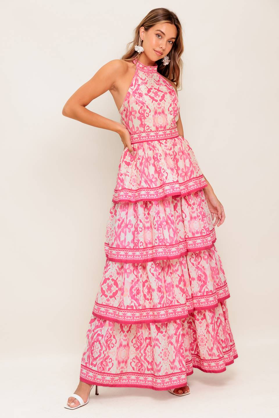 A printed woven maxi dress featuring halter neckline, sleeveless, layered skirt and back zipper closure