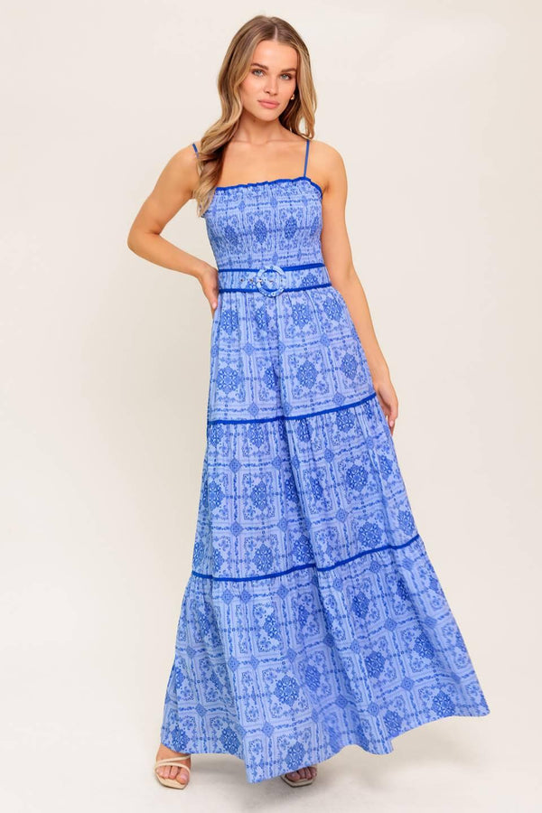 A printed woven maxi dress featuring straight neckline, straps, smocked bodice, self belt and tiered skirt.