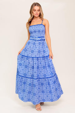 A printed woven maxi dress featuring straight neckline, straps, smocked bodice, self belt and tiered skirt.