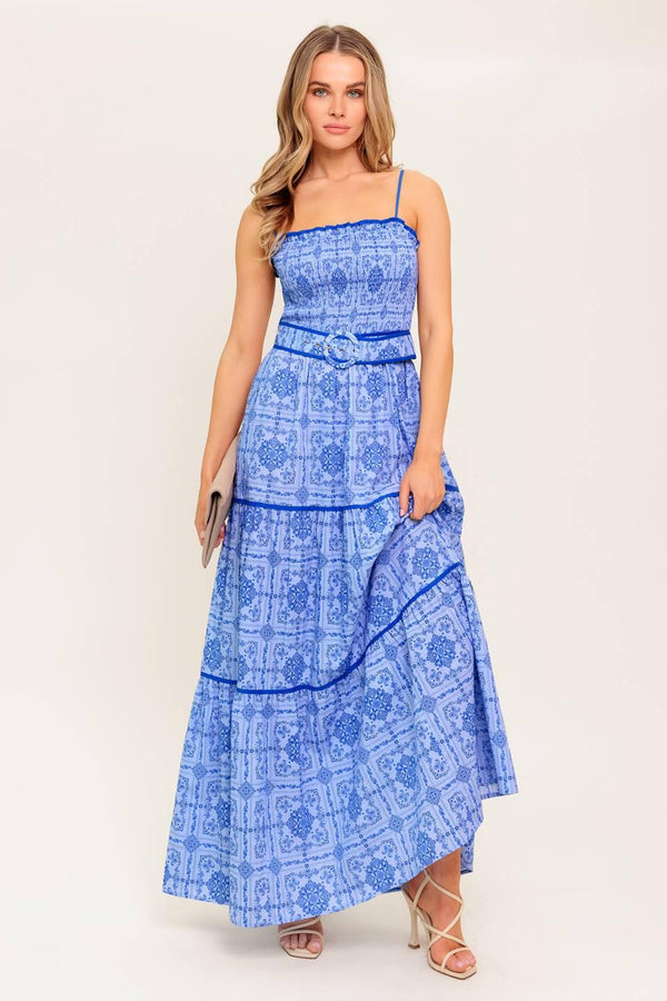 A printed woven maxi dress featuring straight neckline, straps, smocked bodice, self belt and tiered skirt.