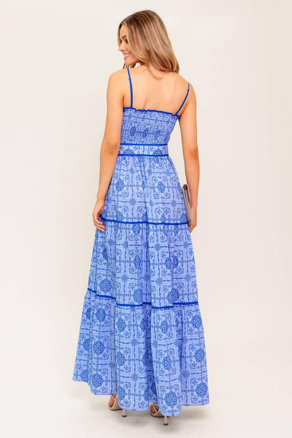 A printed woven maxi dress featuring straight neckline, straps, smocked bodice, self belt and tiered skirt.