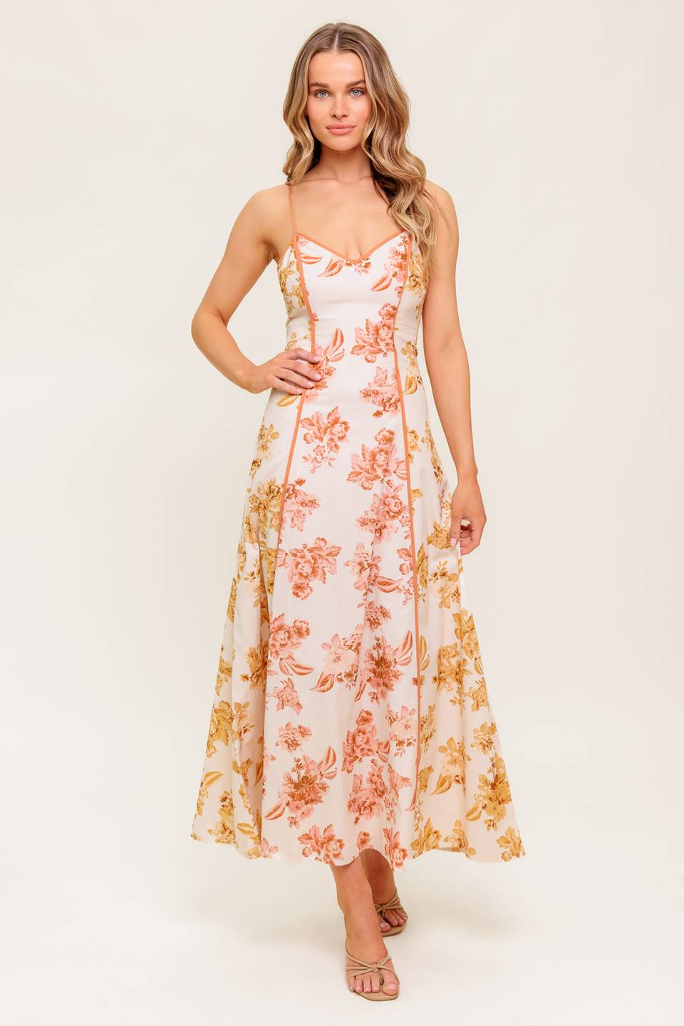 A floral printed woven midi dress featuring cami top, circle skirt and back zipper closure.