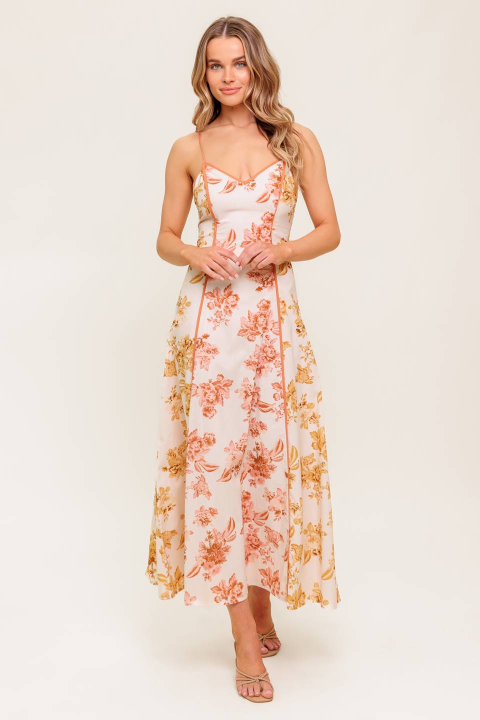 A floral printed woven midi dress featuring cami top, circle skirt and back zipper closure.