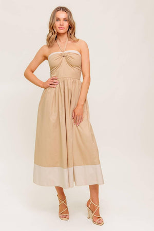 A solid woven midi dress featuring sweetheart neckline with gathered front, halter tie, full skirt and smocked back bodice.