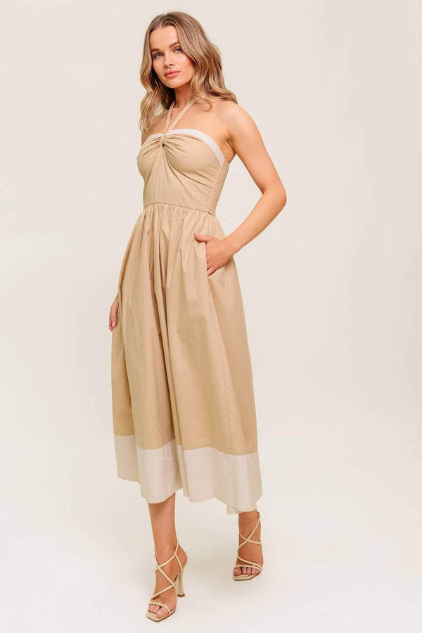 A solid woven midi dress featuring sweetheart neckline with gathered front, halter tie, full skirt and smocked back bodice.